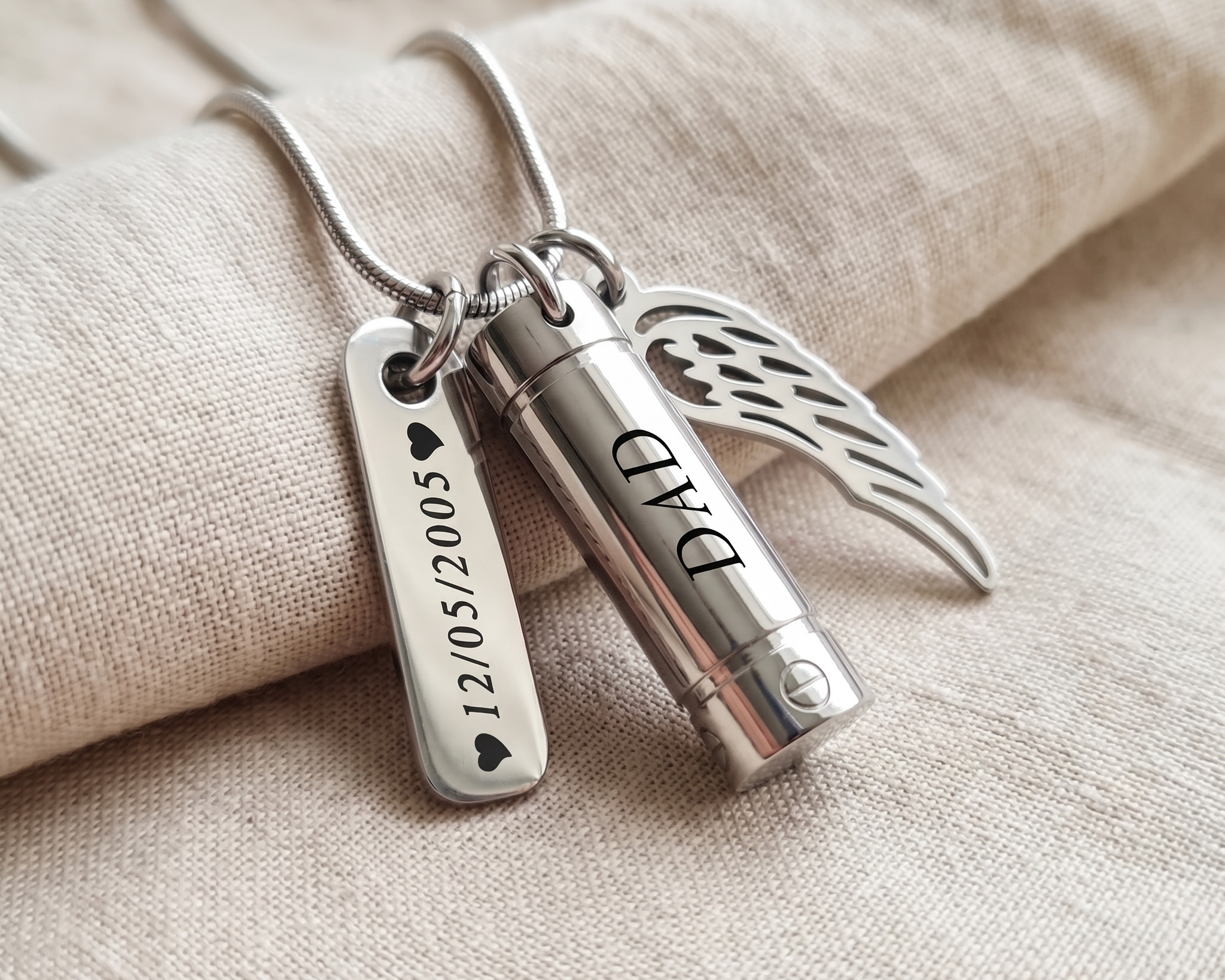Three pendants in silver, gold and rose gold tones laid in a row