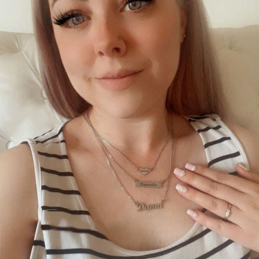 Woman styling layered personalised name necklaces by Belle Fever, showing meaningful daily wear jewellery that tells your story