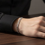 Silver curb chain bracelet styled on wrist, waterproof non-tarnish jewelry for modern unisex everyday wear.