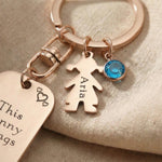 Close-up of kids personalised tag keyring with engraved message, child charm and birthstone detail
