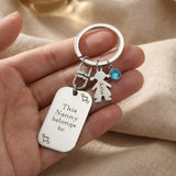 Hand holding kids personalised tag keyring with engraved detail, family
