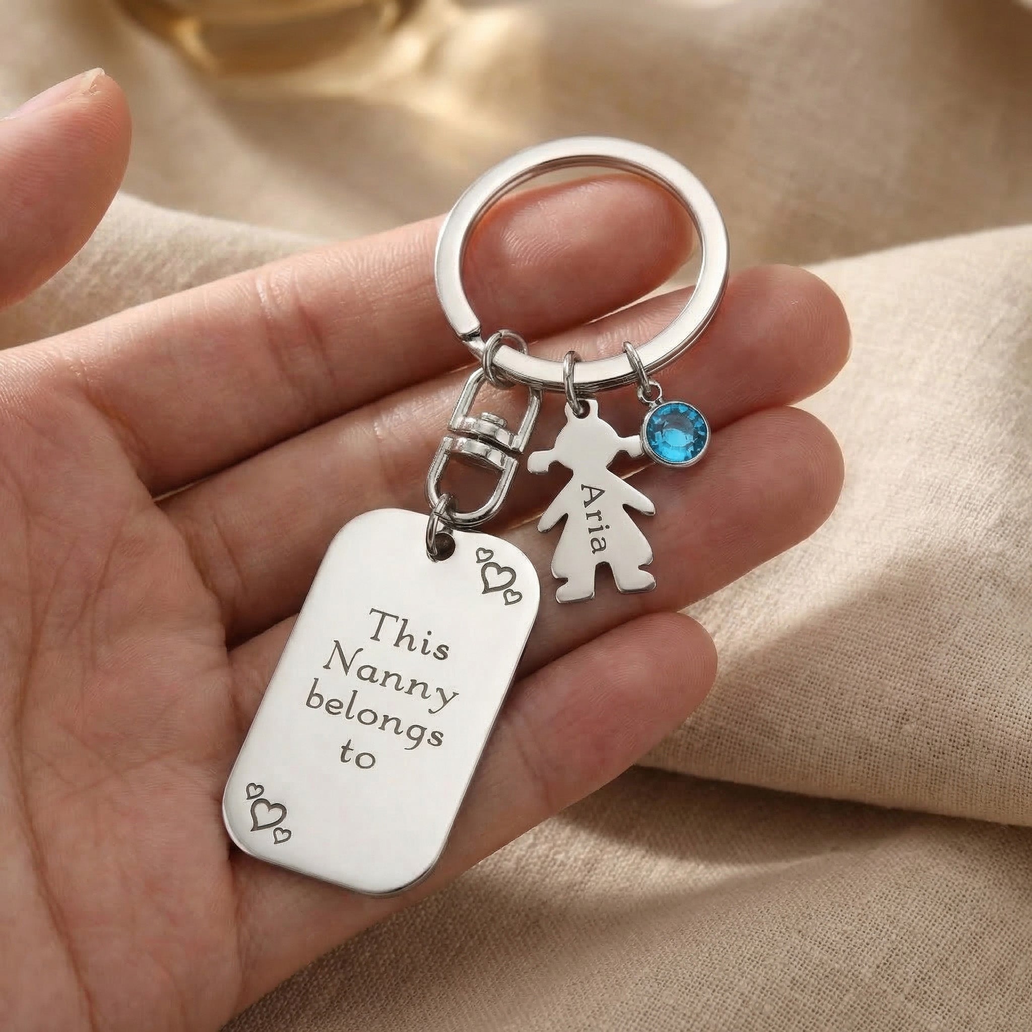 Hand holding kids personalised tag keyring with engraved detail, family