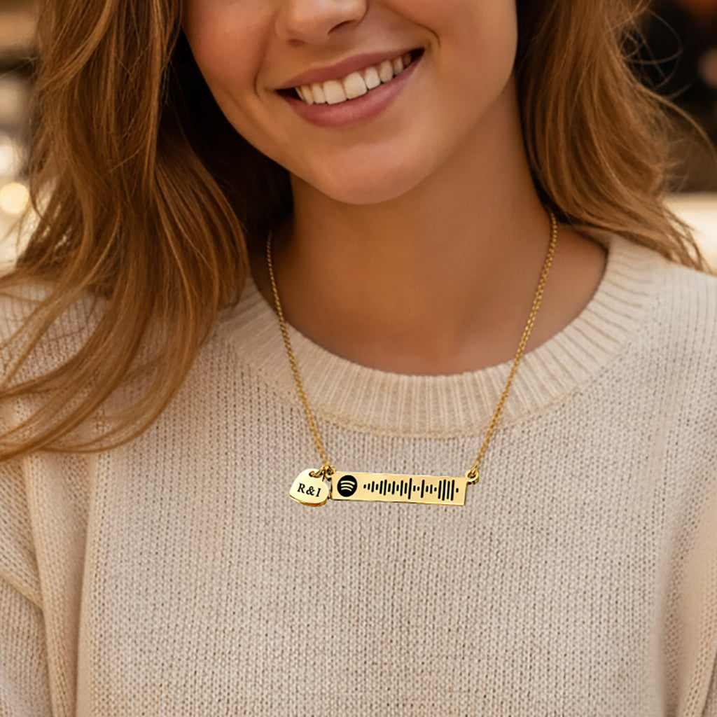 Model wearing a personalized bar necklace with engraved song code and heart charm by Belle Fever