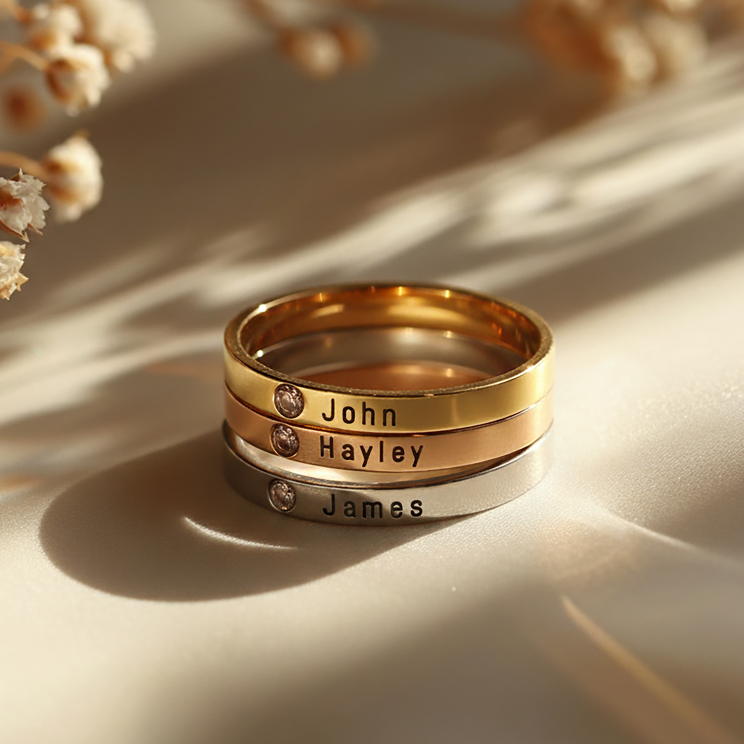 Gold Stackable Birthstone Rings by Belle Fever — engraved family name bands with shimmering birthstones, a heartfelt way to honour loved ones.