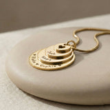 Close-up of the Tower of Love necklace by Belle Fever, with layered round charms, displayed on a minimal background