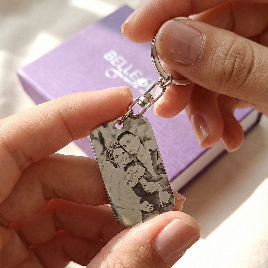 Hand holding a personalized photo tag keyring with custom engraved calendar date