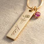 Close up of birthflower personalised necklace with engraved bar and birthstone charm detail
