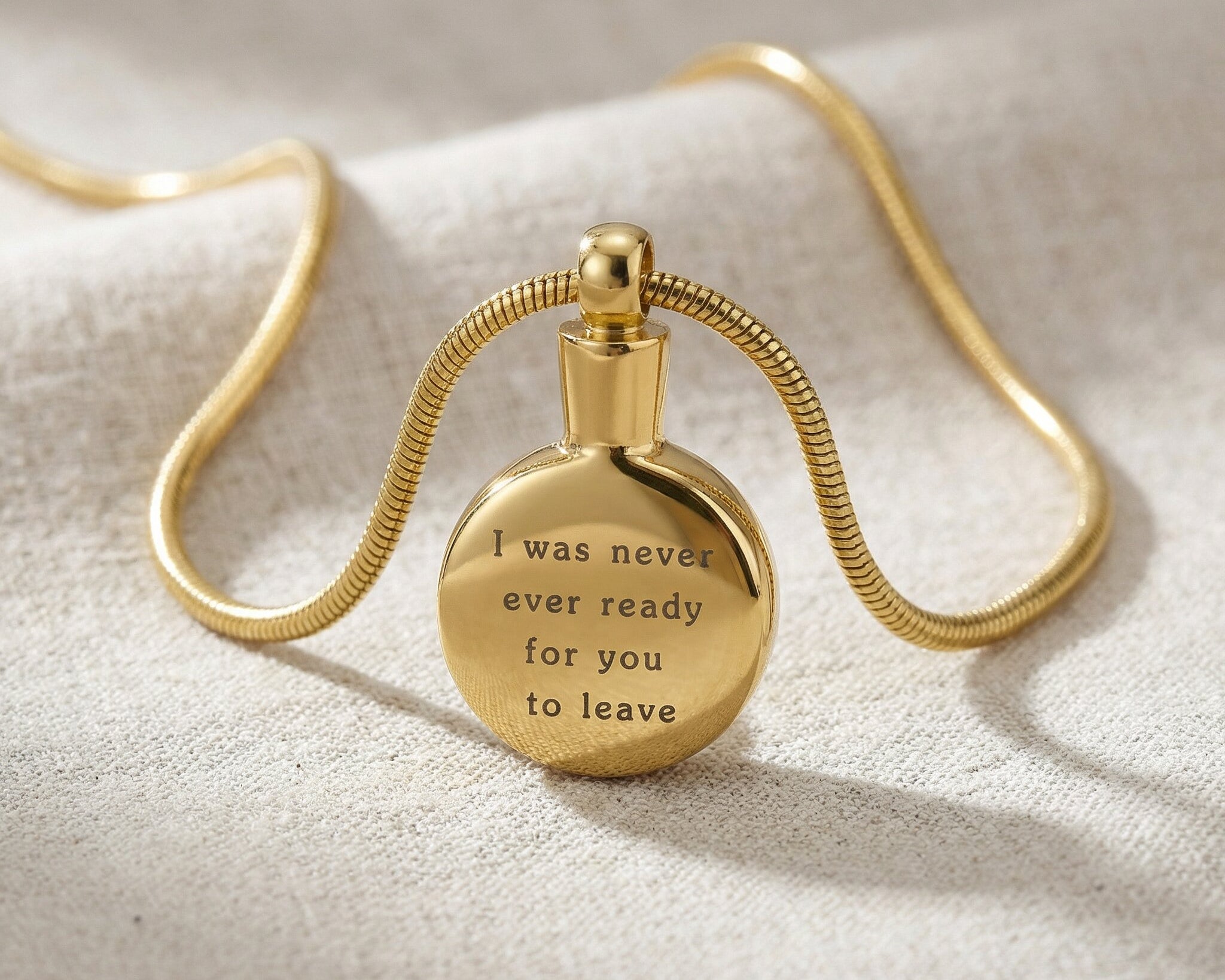 Gold circle cremation necklace with round urn pendant displayed on neutral background