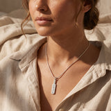 A model wearing cricket bat name necklace with engraved pendant, sporty personalised style