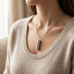 Woman wearing cylinder cremation necklace with urn pendant on delicate chain