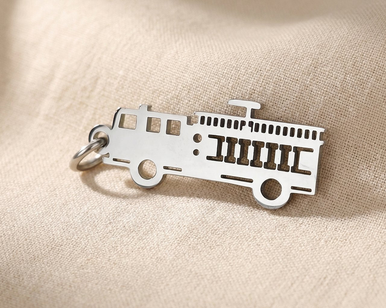Silver fire truck charm for keyring honoring firefighters, bravery, and emergency service dedication