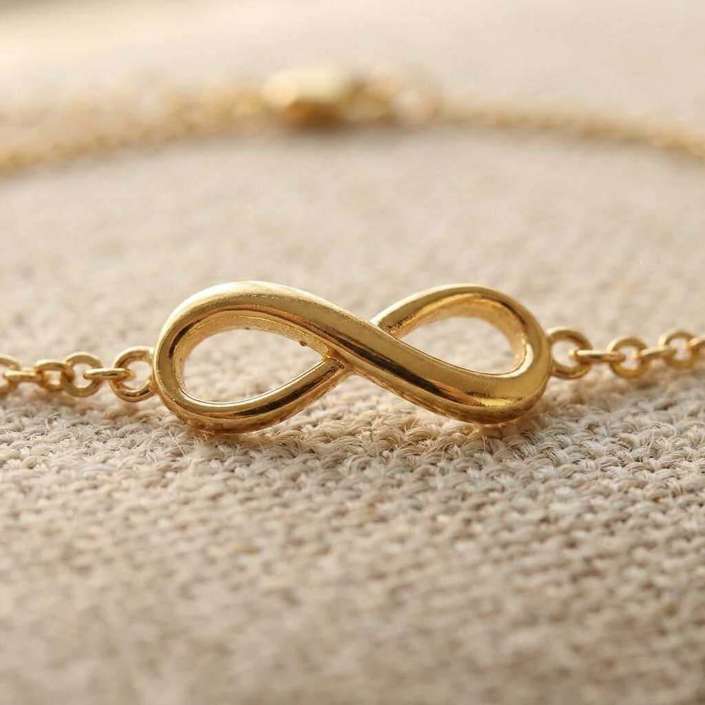 Close up of infinity bracelet with polished infinity symbol on fine chain