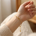 Woman wearing infinity bracelet with delicate chain and infinity symbol design
