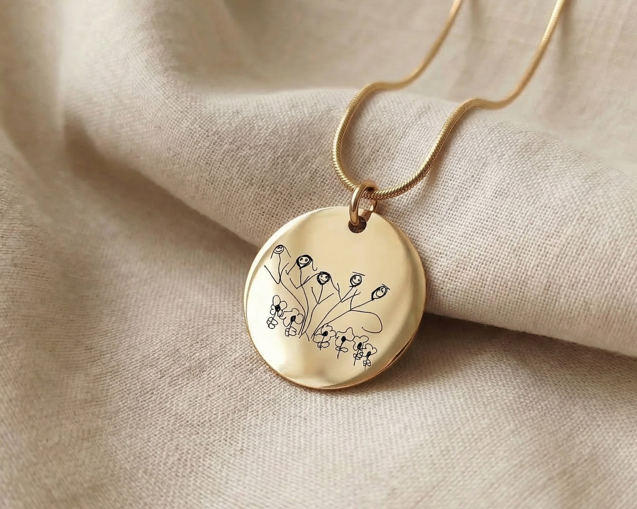 Gold kids drawing necklace with custom engraved artwork displayed on neutral background