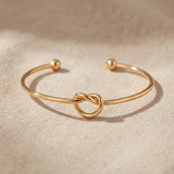 Knot bangle in gold with symbolic knot design, meaningful open cuff bracelet jewellery gift for her