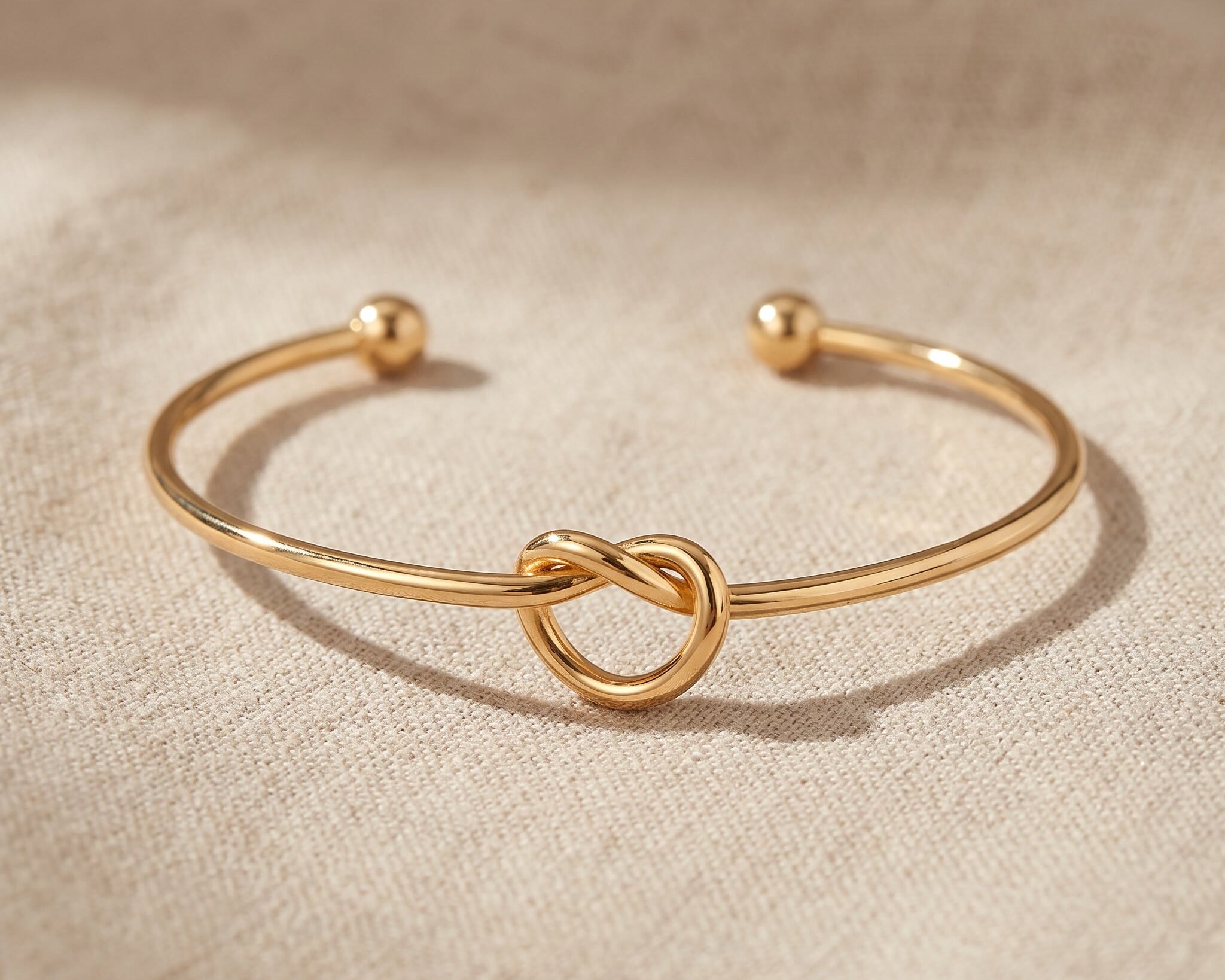 Knot bangle in gold with symbolic knot design, meaningful open cuff bracelet jewellery gift for her