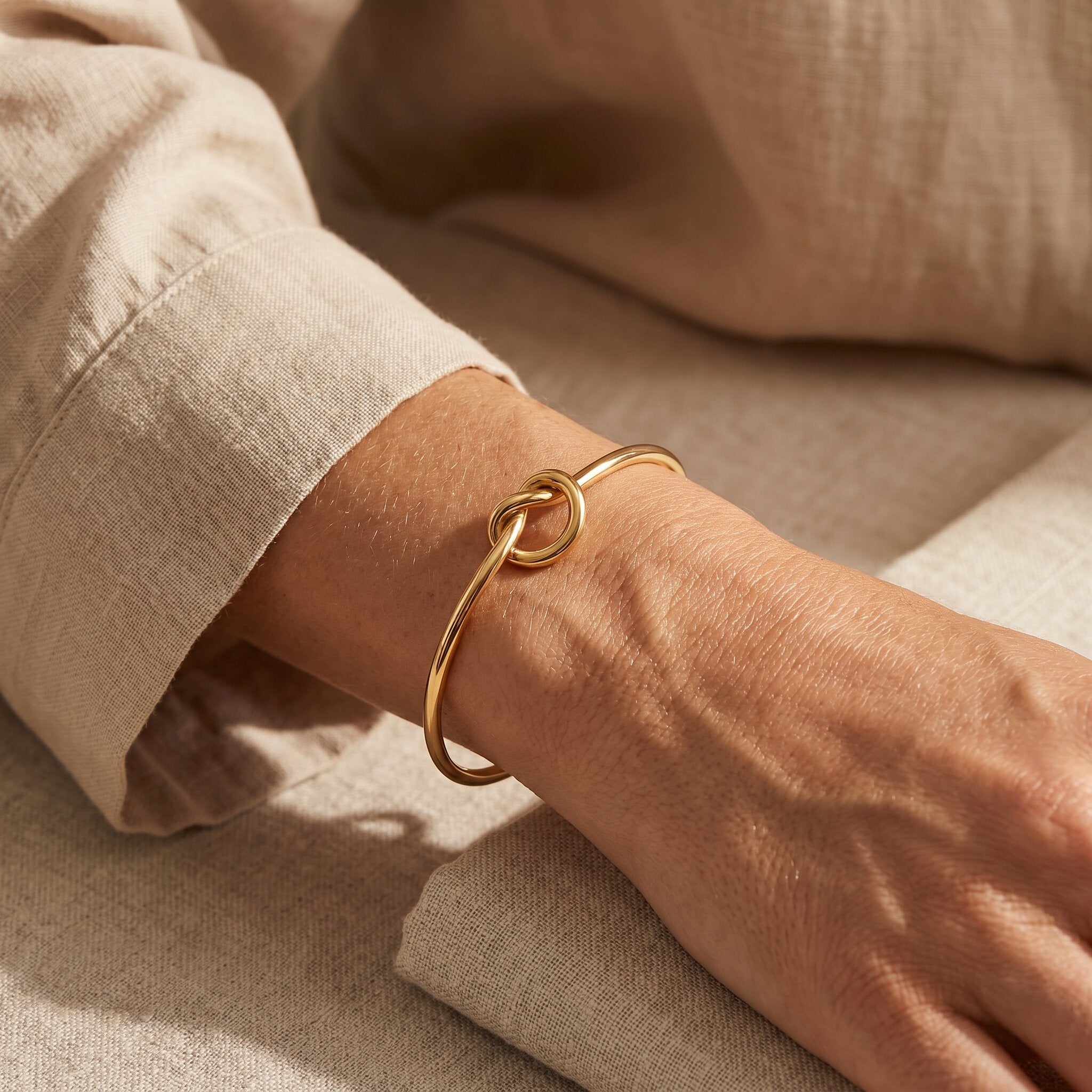 Woman wearing knot bangle, minimalist symbolic bracelet representing love, connection and family bond