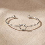 Knot bangle in silver with symbolic knot design, elegant open cuff bracelet gift for her