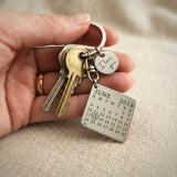 Person holding personalised calendar keyring with engraved date calendar tag