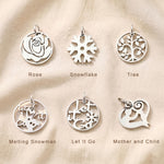 Symbolic charm collection for personalized keyrings featuring roses, snowflakes, family tree, and inspirational designs