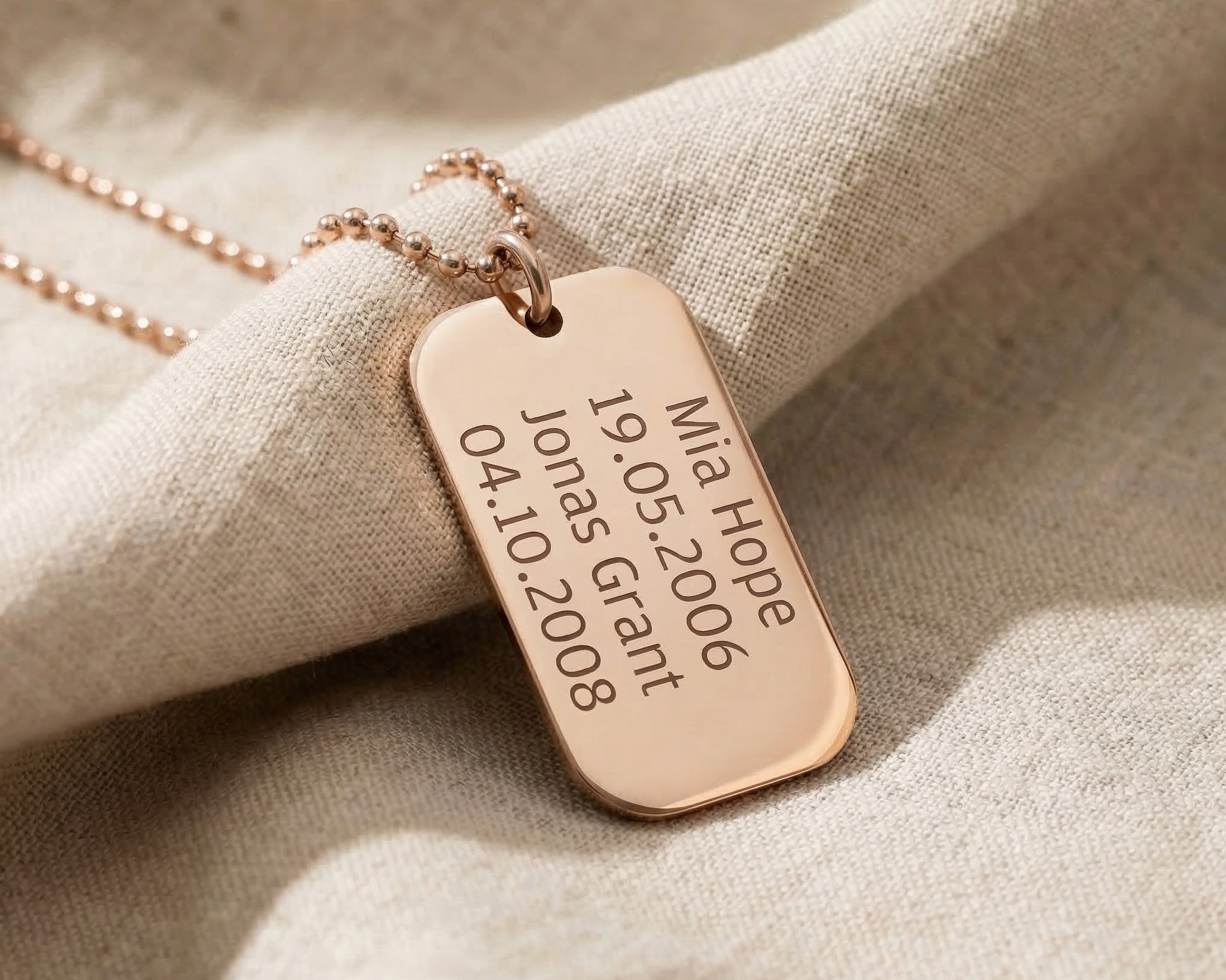 Personalised dog tag necklace in rose gold with engraved text, elegant custom jewelry piece