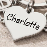Close-up of personalised keyring charm with engraved name on heart-shaped charm
