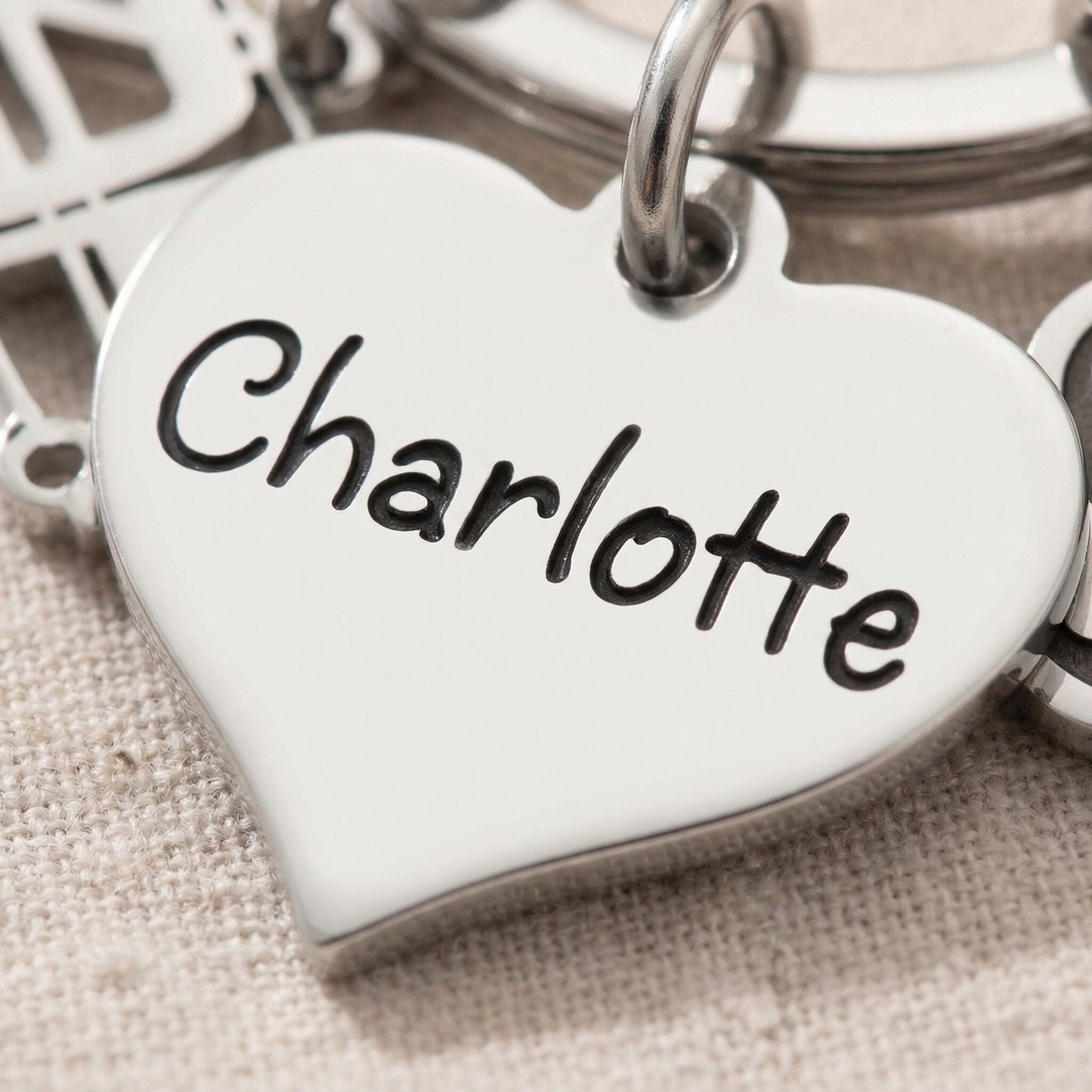 Close-up of personalised keyring charm with engraved name on heart-shaped charm