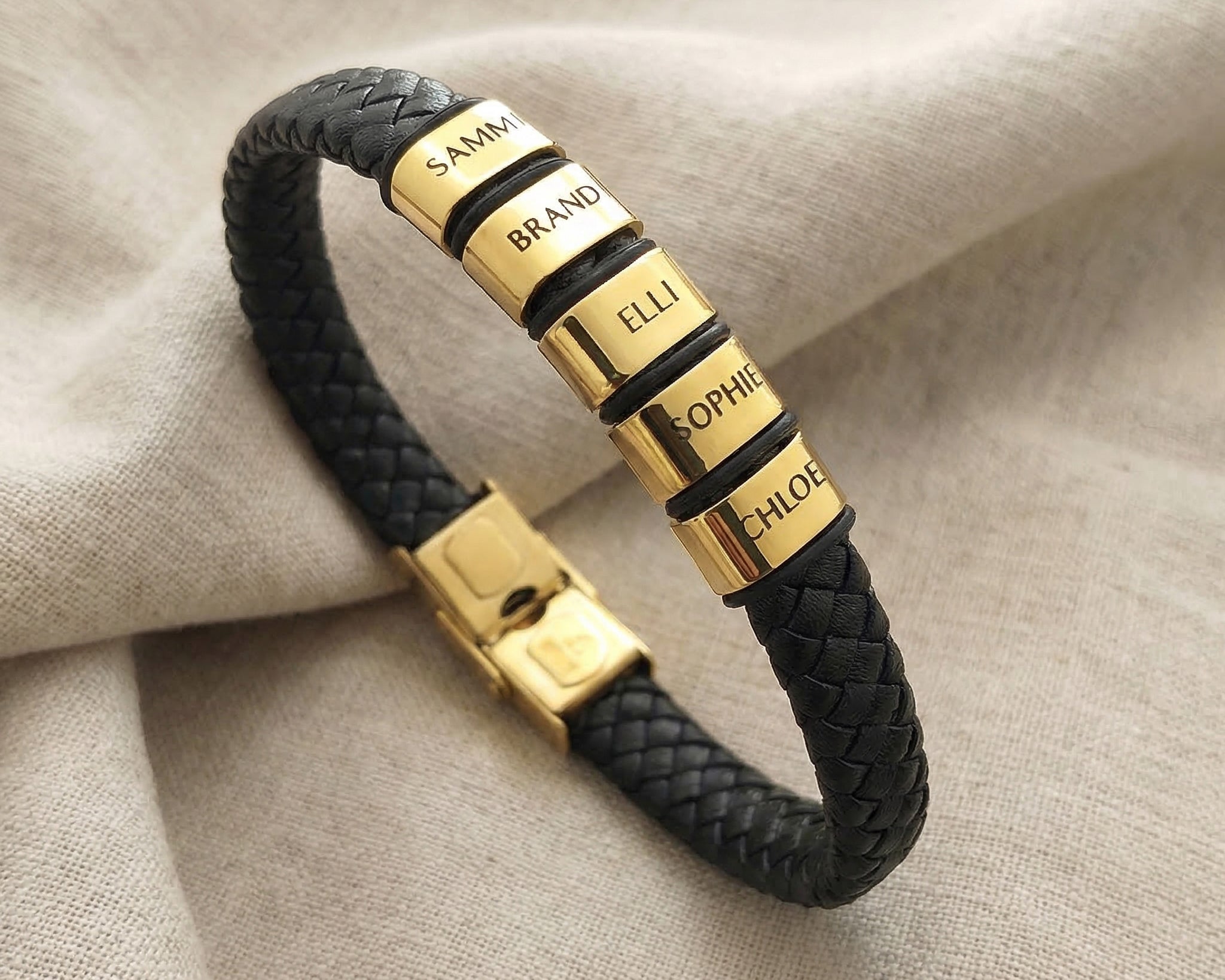 Personalised black leather bracelet with multiple engraved name charms showing customisation option
