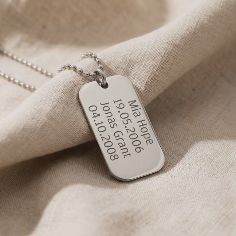 Personalised dog tag necklace with engraved message shown in close-up product view