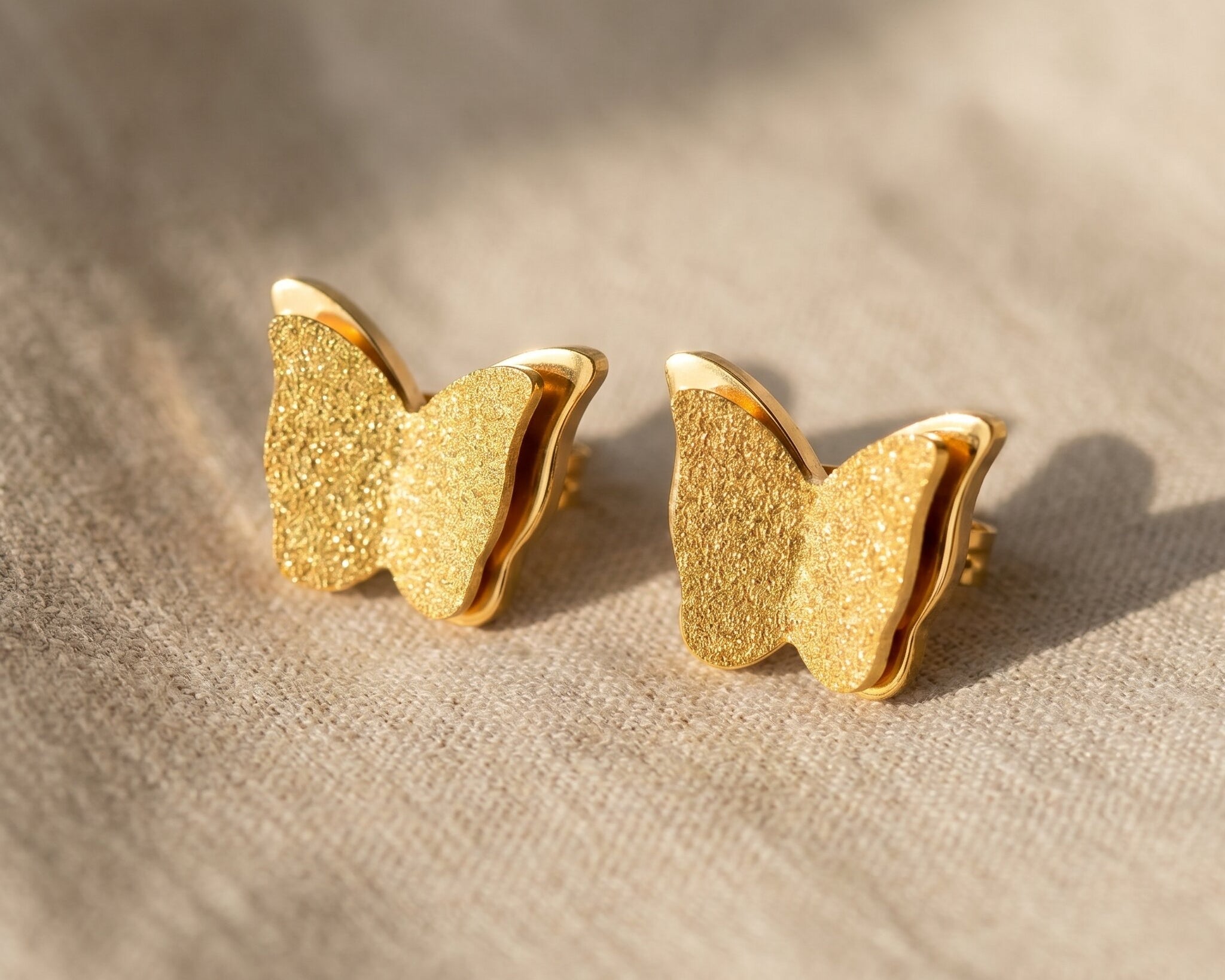 Sparkling butterfly earrings in gold with textured detail, symbolic jewellery gift for her